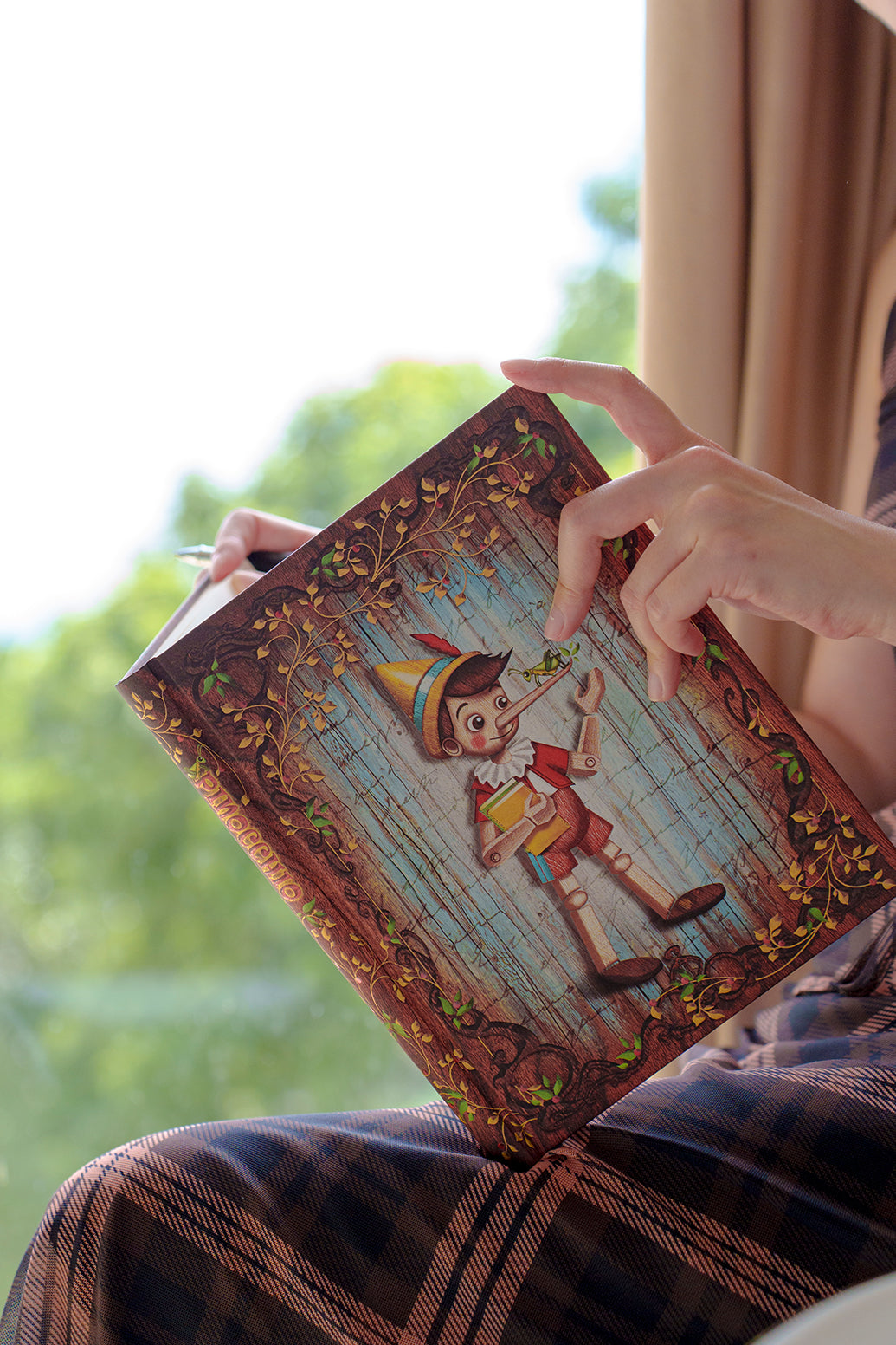 Paperblanks Carlo Collodi, Pinocchio Midi Hardback Journal – Lined, 144 Pages – lifestyle image