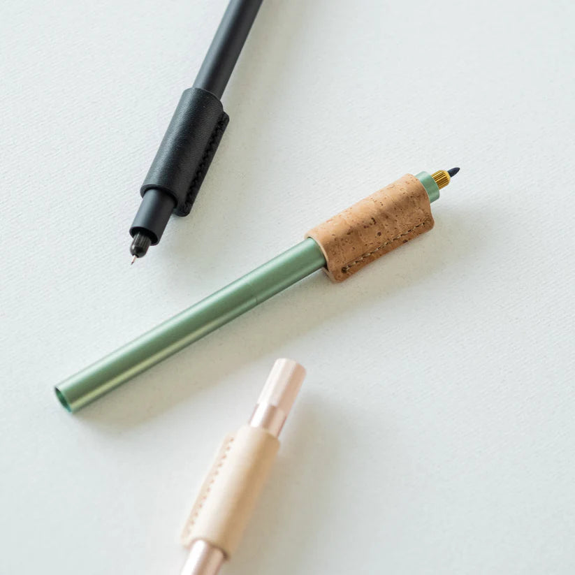 Three pens with cork accents on a white surface