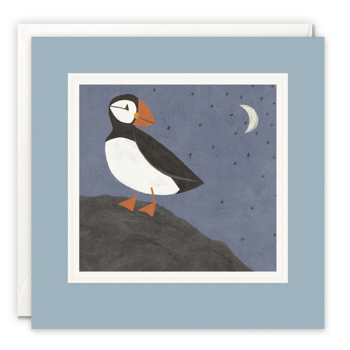 Puffin standing on a dark rock under a crescent moon and stars in a dusky blue sky