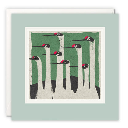 Graphic print of a group of red-capped cranes with long white necks against a green background