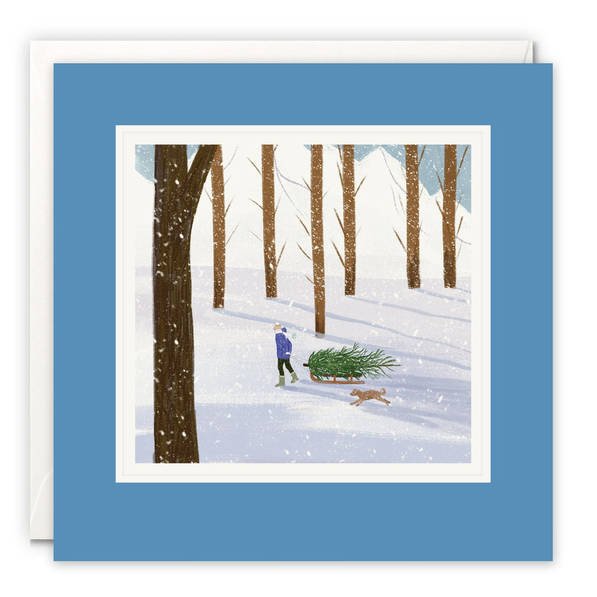 Person pulling a Christmas tree on a sled through a snowy wood with a dog running beside