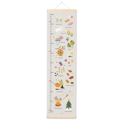 Grey canvas height chart illustrated with the months of the year and seasonal motifs from snowdrops to a Christmas tree