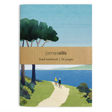 A6 notebook cover showing two cyclists on a clifftop path under pine trees beside a blue bay