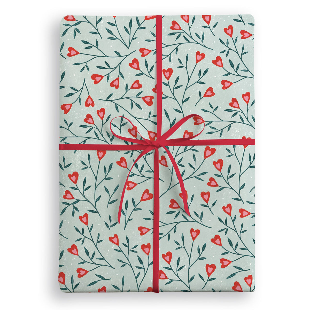 Pale green wrapping paper with trailing leafy stems and small red hearts, tied with a red ribbon