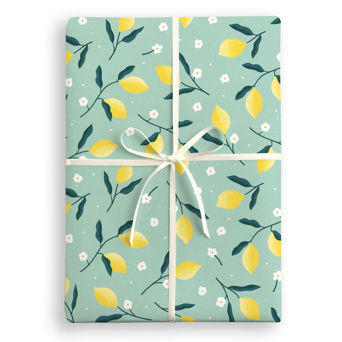 Sage green wrapping paper with yellow lemons, dark leaves and white blossom, tied with a cream ribbon