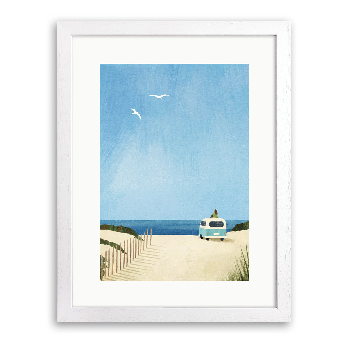 White wood framed print of a pale blue campervan on sand dunes facing the sea with a figure on its roof