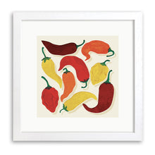 White wood framed print of red, orange and yellow chillies with green stalks on a cream background